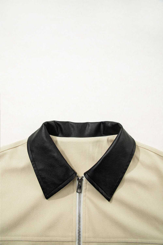 Close-up of black leather collar on the beige corduroy jacket, emphasizing the stylish contrast trim for fall outerwear.
