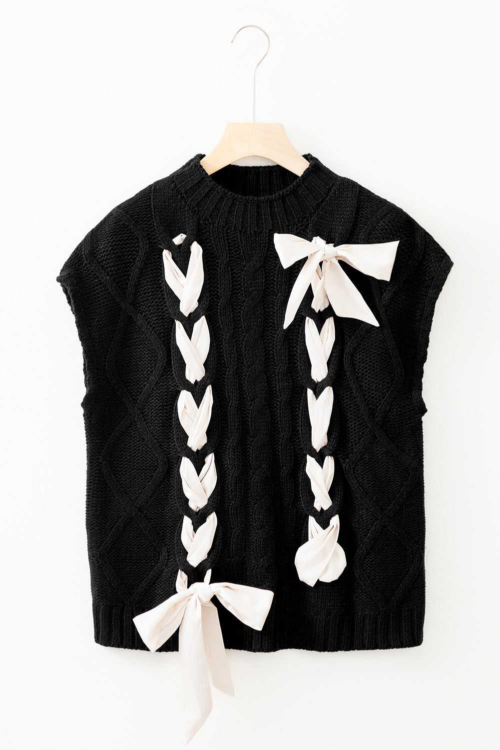 Flat lay of the black Satin Bowknot Short Sleeve Sweater with cream satin bows, showcasing its elegant cable knit and feminine accents.