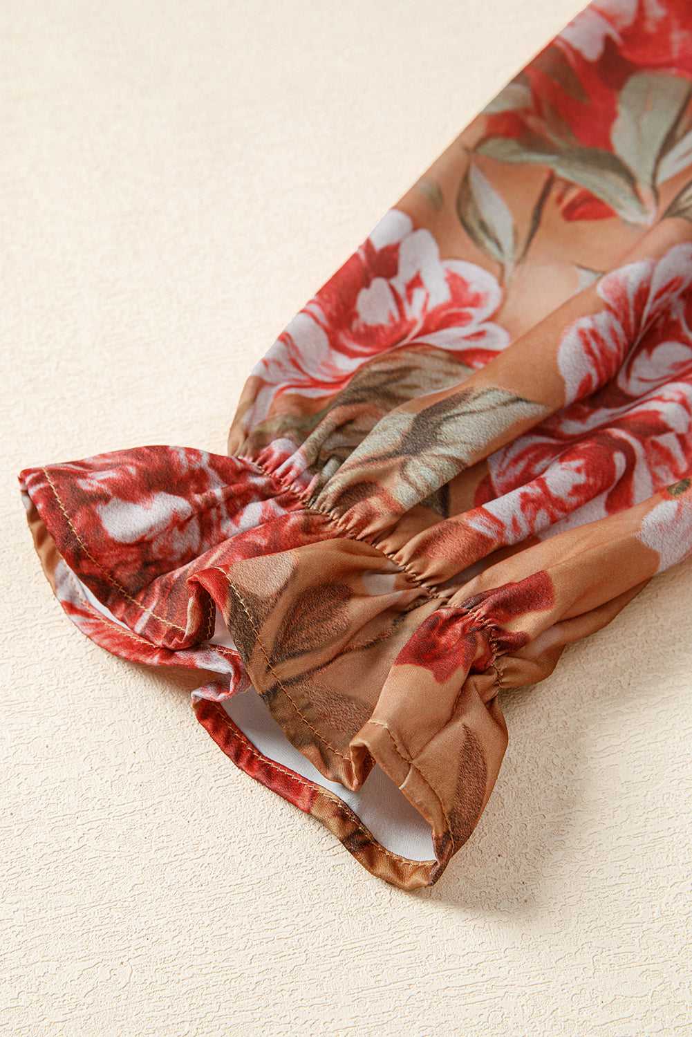 Detailed view of Retro Floral Ruffle Mini Dress sleeve with elastic cuff and ruffle trim, showcasing floral design and stitching.