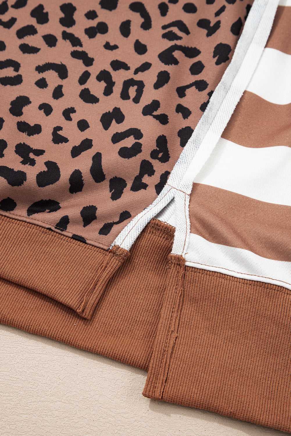 Close-up of hem and side slit stitching on Curve Khaki Leopard Stripe Baggy Sweatshirt, highlighting quality patchwork craftsmanship.