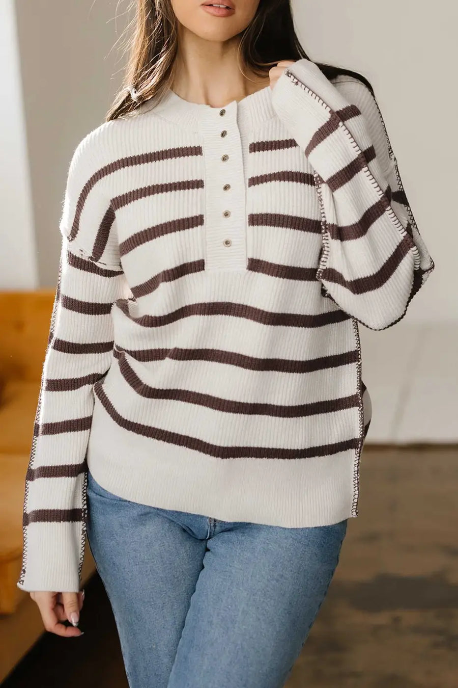 Casual slouchy striped Henley jumper in cream and brown, styled with jeans, ideal for cozy everyday wear.