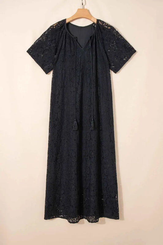 Black Lace Overlay Maxi Sundress displayed on hanger, featuring short sleeves, tassel tie neckline, and elegant floral lace fabric.