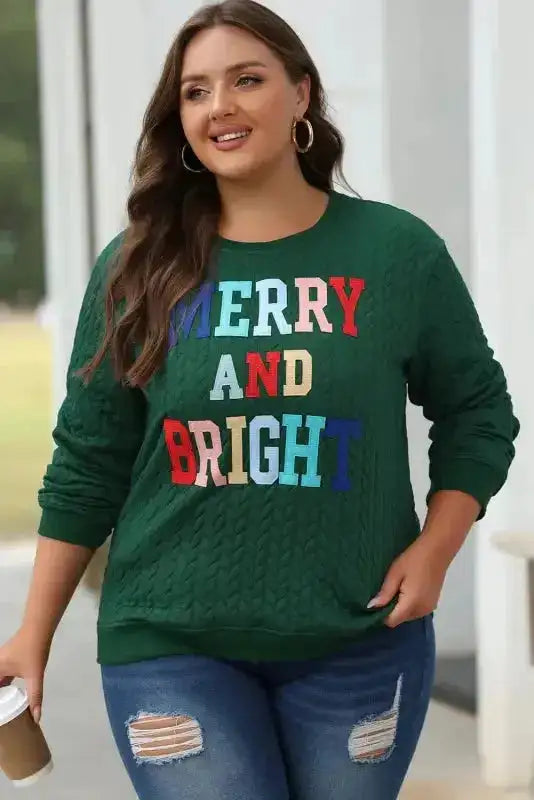 Plus-size model in green Chenille Embroidered Sweatshirt with 'MERRY AND BRIGHT' text, styled for cozy winter fashion.