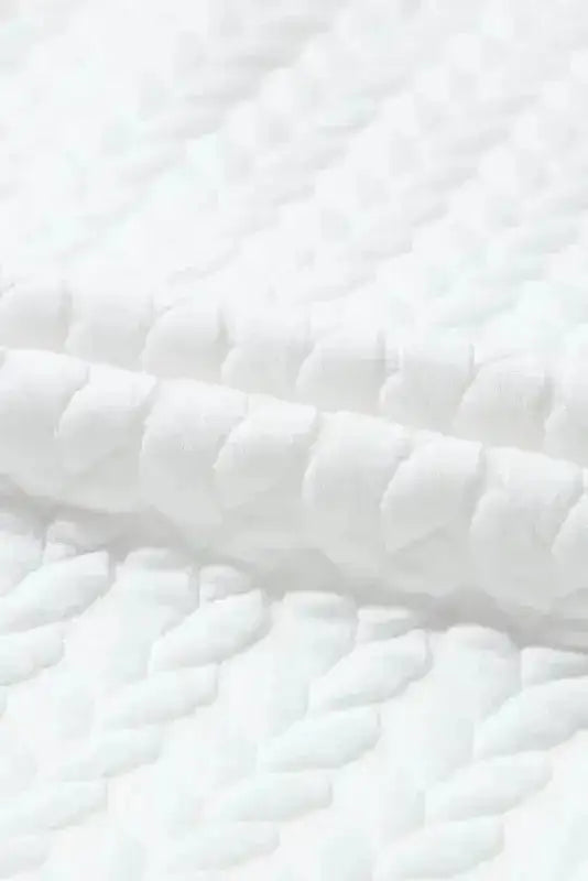 Close-up of white cable knit fabric texture used in Chenille Embroidered Sweatshirts from Graphic Collection FashionFitz.