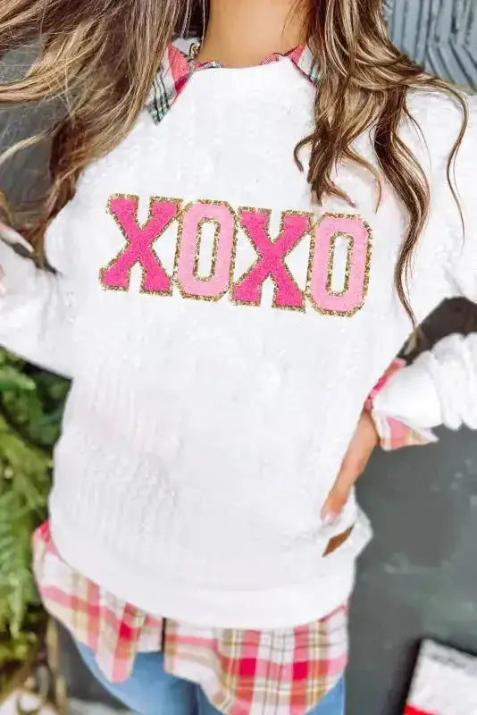 Close-up of pink and gold 'XOXO' chenille embroidery on white sweatshirt, part of Graphic Collection FashionFitz.