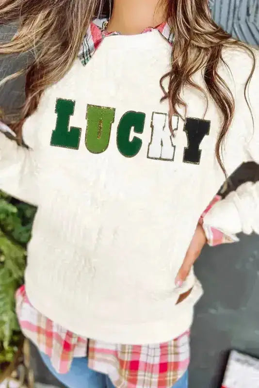 Close-up of Chenille Embroidered Sweatshirt with 'LUCKY' lettering, showcasing textured cable knit and bold graphic design.
