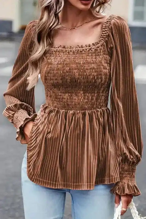 Smocked velvet babydoll top in chestnut with ribbed texture, square neckline, and long bubble sleeves styled with light denim jeans.