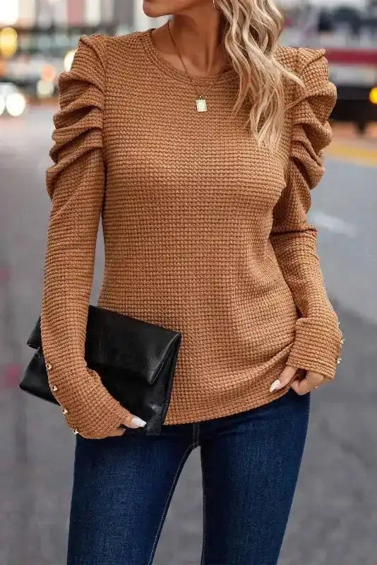 Front view of FashionFitz Chestnut Textured Top with puffed gigot sleeves and round neckline, paired with skinny jeans and a black clutch.