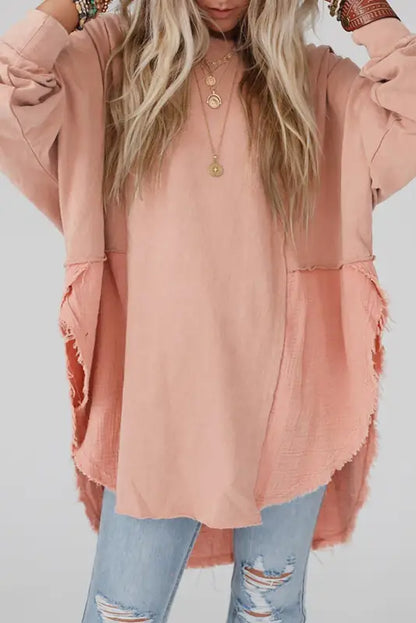 Chic high-low hem oversized blouse with exposed seam design, paired with distressed blue jeans