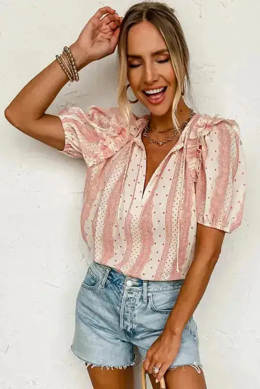 Chic Peek Puff Sleeve Blouse in pink polka dot print with ruffle accents, styled with casual denim shorts for summer fashion.