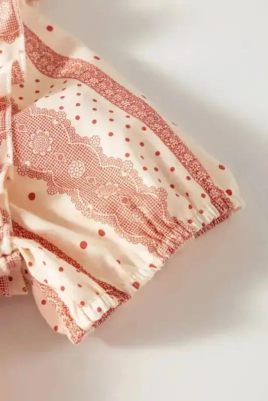 Detail of Chic Peek Blouse puff sleeve with elastic hem and pink polka dot stripe pattern on soft cotton fabric.