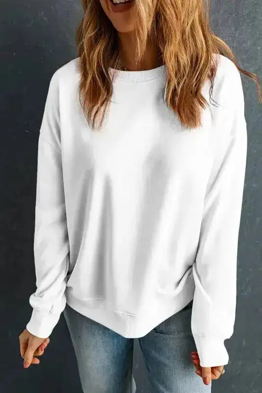 White cozy crewneck sweatshirt worn casually with jeans. A must-have winter top for effortless style and warmth.