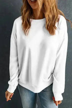 White cozy crewneck sweatshirt worn casually with jeans. A must-have winter top for effortless style and warmth.