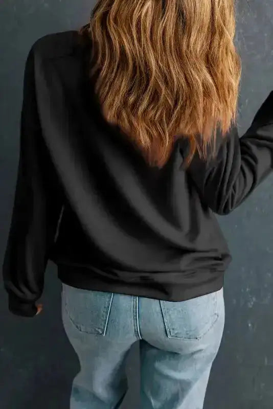 Back view of black crewneck sweatshirt. Relaxed fit with ribbed hem and cuffs for added comfort.