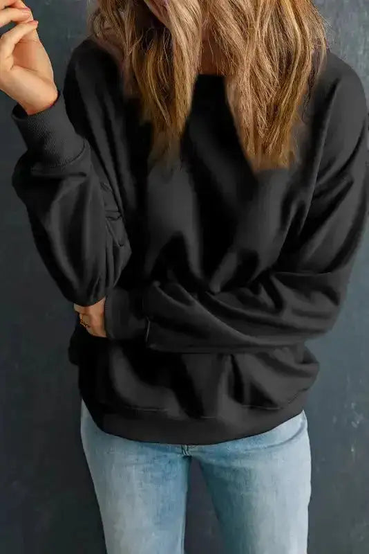 Black crewneck sweatshirt with long sleeves and soft fabric. Ideal for layering and everyday winter wear.