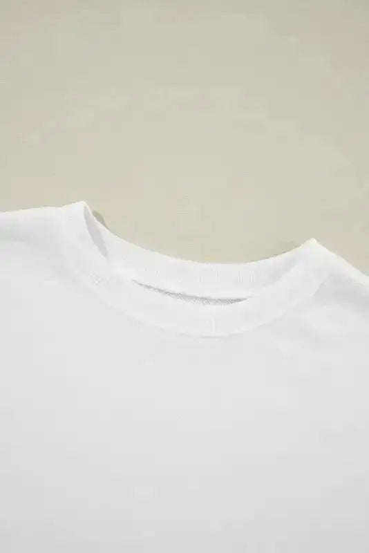 Close-up of white crewneck sweatshirt collar. Soft ribbed neckline enhances comfort and durability.