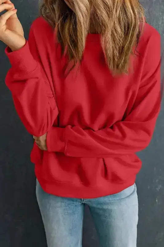 Red crewneck sweatshirt with relaxed fit and ribbed cuffs. A vibrant and warm choice for cold seasons.