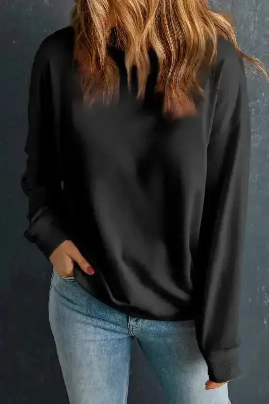 Black classic crewneck sweatshirt paired with jeans. A sleek and cozy winter essential for casual looks.