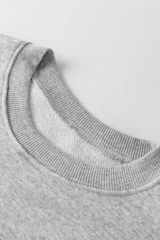 Close-up of gray sweatshirt neckline. Ribbed collar detail adds a touch of texture and comfort.
