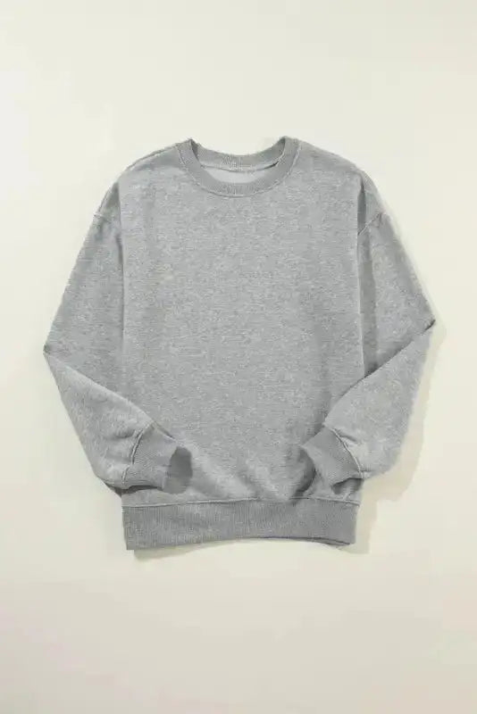 Flat lay of gray crewneck sweatshirt. Simple solid color design perfect for casual and everyday wear.