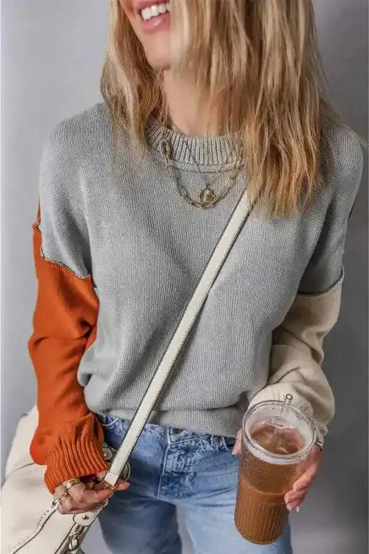 Smiling model in Coffee Leopard Print Colorblock Pullover Sweater - New, holding iced coffee and showcasing cozy knitwear style.