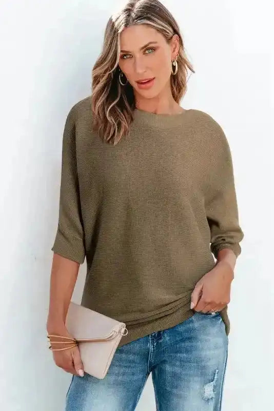 Women’s coffee ribbed half sleeve knit jumper styled with blue denim and a beige clutch, offering a soft and breathable fall look.