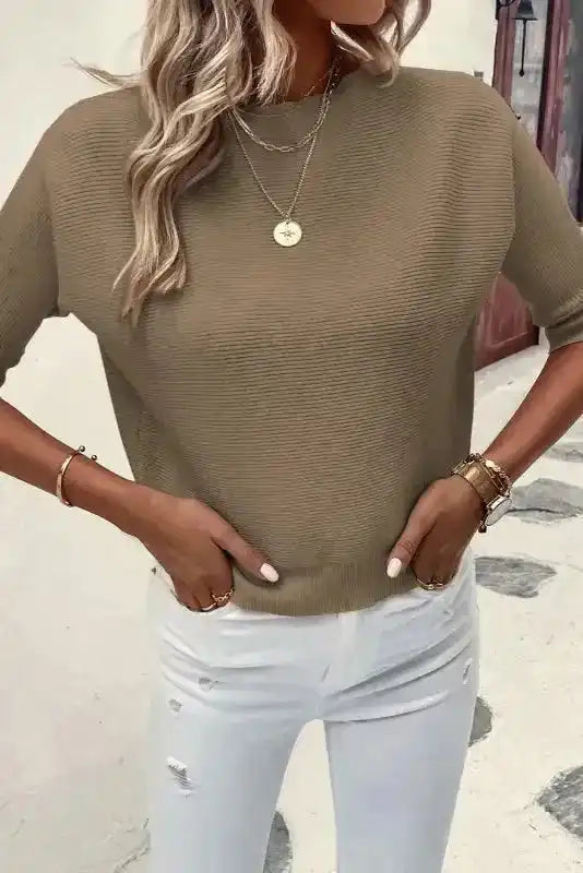 Casual women’s coffee knit jumper with ribbed texture and short sleeves, styled with white ripped jeans for a relaxed fall look.