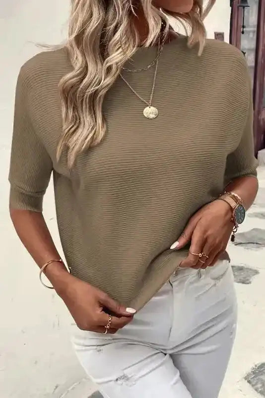 Women’s ribbed coffee knit jumper with half sleeves styled with white jeans and layered gold jewelry for a casual fall outfit.