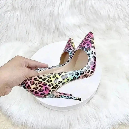 Hand holding FashionFitz Vivid Leopard Stilettos highlighting glossy PU leather and rainbow leopard print, perfect for daily or event wear.