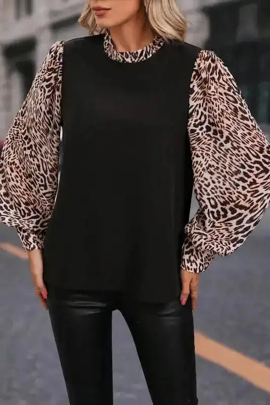 Elegant black blouse with voluminous leopard print sleeves, ideal for daily wear or stylish autumn outings.