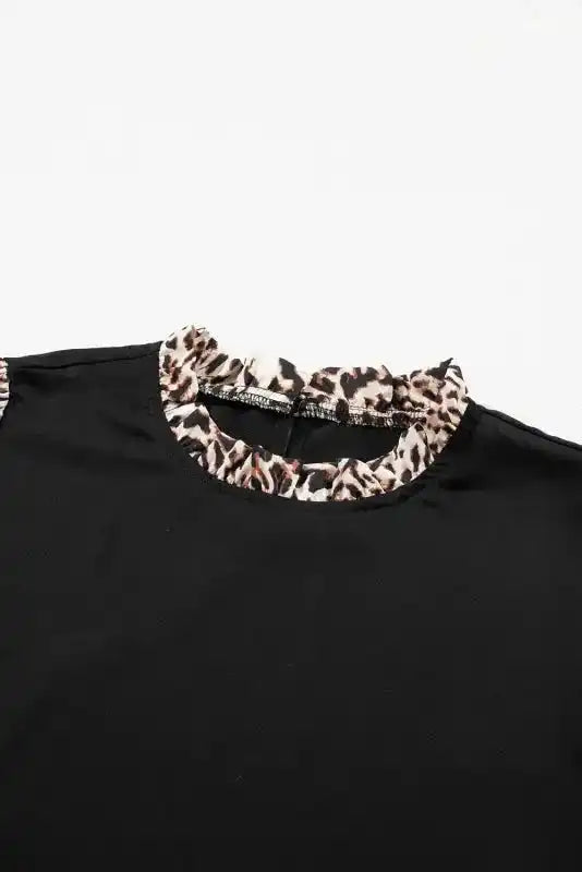 Close-up of ruffled neckline on Contrast Leopard Sleeve Blouse, featuring soft leopard print trim for a stylish touch.