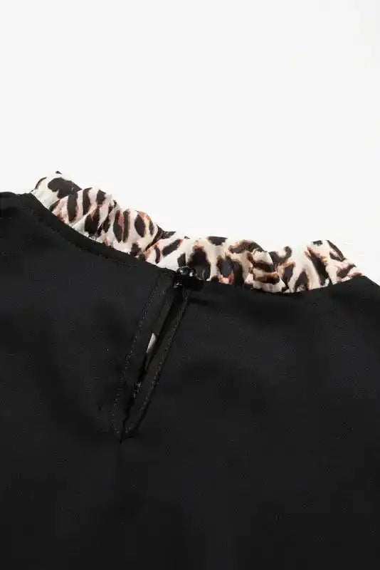 Detail of back neckline with button closure on Contrast Leopard Sleeve Blouse - Chic Black, emphasizing quality craftsmanship.