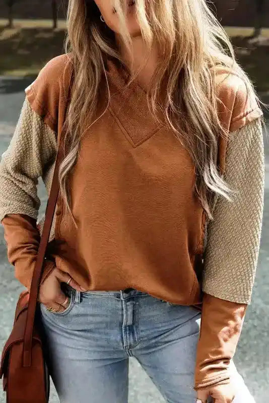 Brown Contrast Patchwork Hoodie styled with jeans, featuring beige sleeves for a cozy fall look.