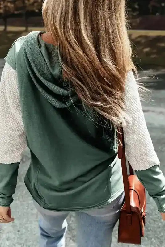 Back view of green Contrast Patchwork Hoodie with beige sleeves, relaxed fit ideal for autumn layering.