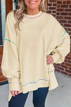 Yellow contrast stitching baggy sweatshirt with split hem and oversized fit, styled with black leggings for casual fall fashion.