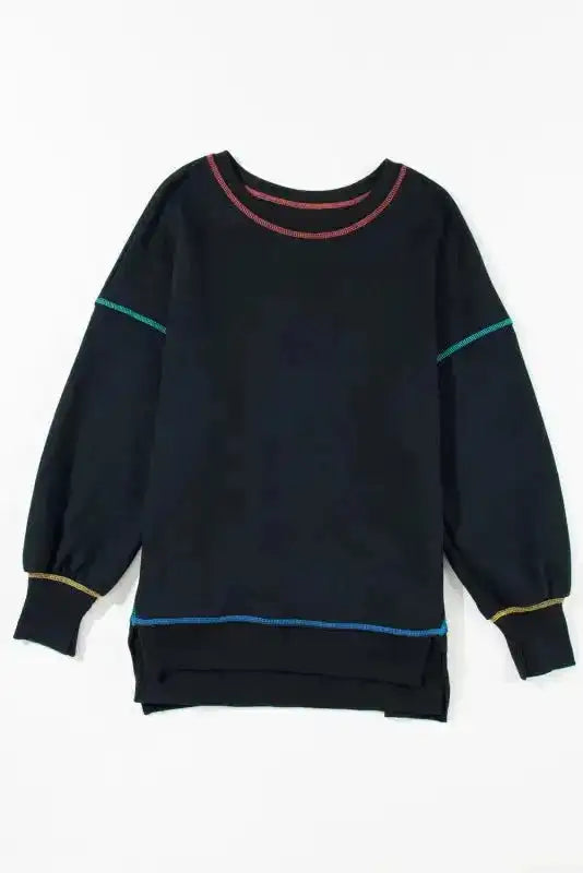 Flat lay of black contrast stitching sweatshirt with split hem and ribbed cuffs, showcasing its oversized silhouette.