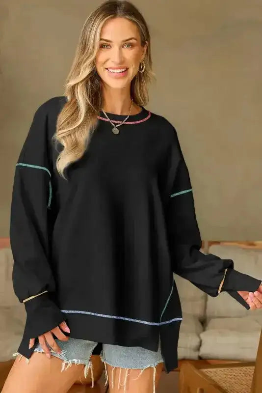 Model wearing black baggy sweatshirt with vibrant stitching and relaxed fit, perfect for versatile everyday streetwear.