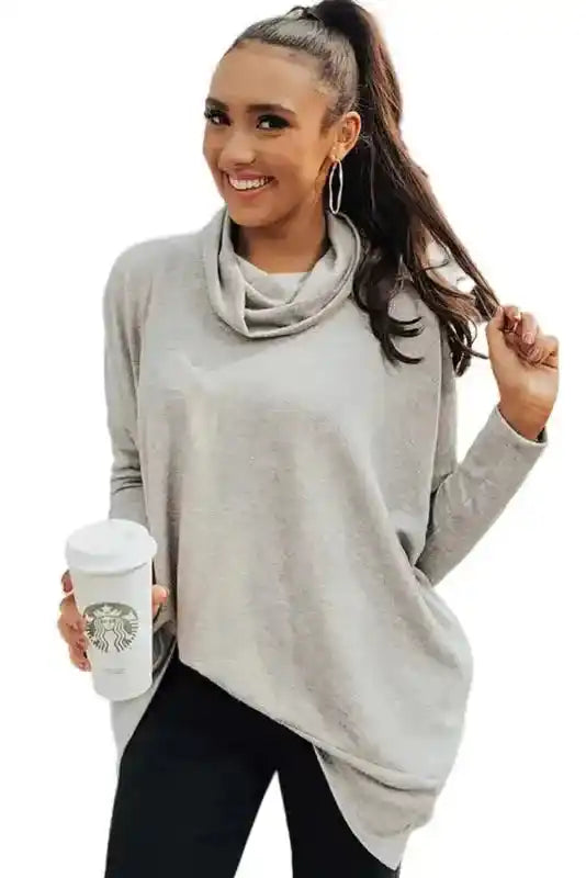 Studio image of gray Versatile Cowl Neck Shift Tunic Top with black pants and coffee cup, showcasing a comfy daily essential.