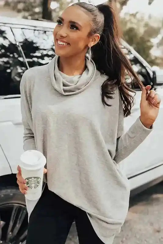 Gray Cowl Neck Shift Tunic Top with long sleeves styled for a casual winter look, paired with black pants and a coffee cup.