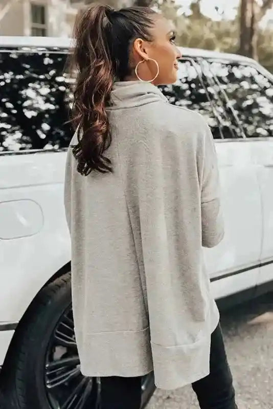 Back view of the gray Versatile Cowl Neck Shift Tunic Top showing its loose fit and high-low hem, ideal for layering in cold seasons.
