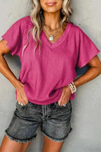 Crinkled V-Neck T-Shirt in vibrant pink with wide sleeves, styled casually with denim shorts for summer wear.