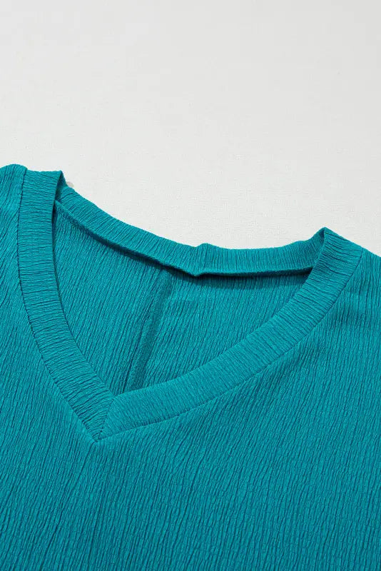 Crinkled v neck wide sleeve t-shirt: teal v-neck shirt with a textured, relaxed fabric surface