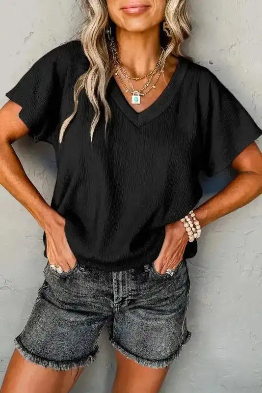 Stylish Crinkled V-Neck T-Shirt in black with wide sleeves, paired with denim shorts for a casual summer look.