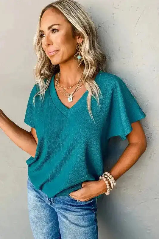 Side angle of teal Crinkled V-Neck T-Shirt highlighting its wide sleeves and textured linen fabric.