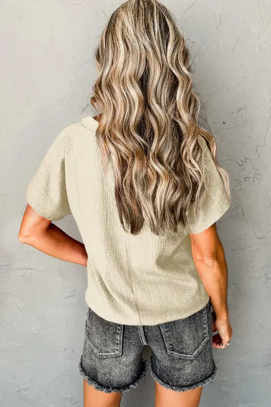 Long, wavy blonde hair cascades in ’black crinkled v neck wide sleeve t-shirt’ look