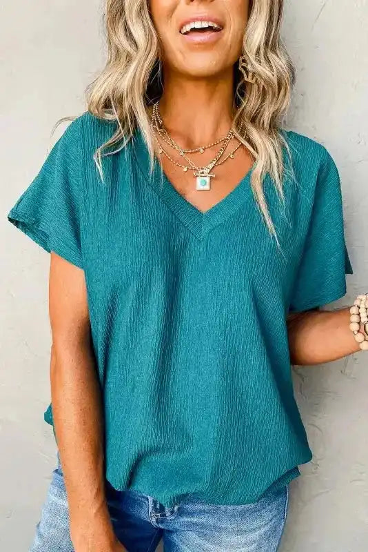 Teal Crinkled V-Neck T-Shirt with wide sleeves, styled with jeans for a fresh and comfortable summer outfit.