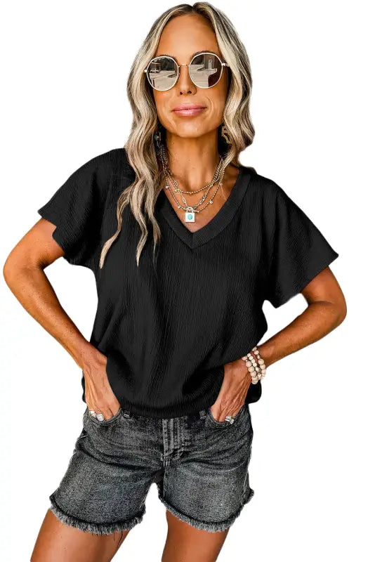 Woman wearing black crinkled v neck wide sleeve t-shirt, perfect for a relax relax style