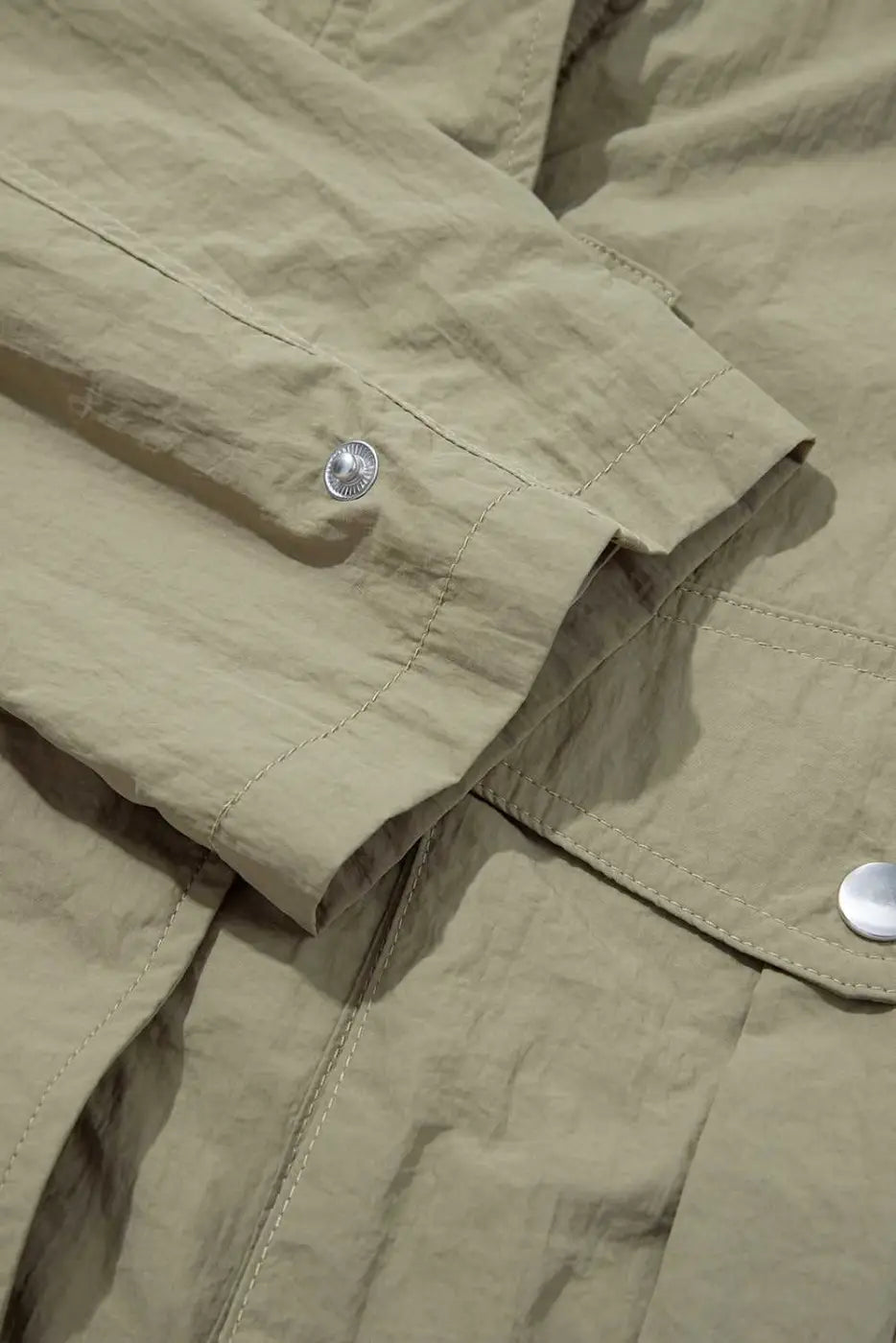 Sleeve and cuff detail of Cropped Hooded Utility Jacket with snap button, emphasizing durable stitching and casual design.