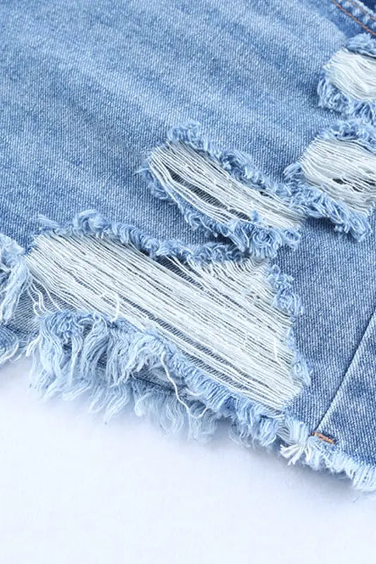 Distressed denim fabric with frayed rips on crossover waist denim shorts for a relaxed look