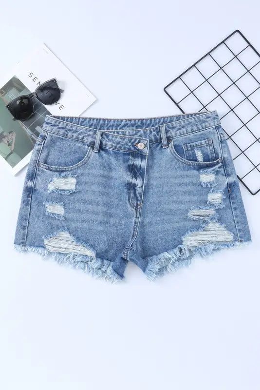 Crossover waist denim shorts in distressed style with frayed edges and ripped details. Relax, relax!